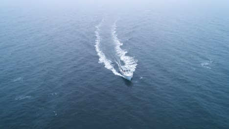 Birds-eye-view-of-a-boat-speeding-across-the-icy-water-of-Maine-USA