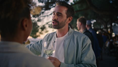 tanned couple enjoying wine at sunset cityscape closeup. man holding wineglass