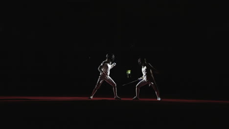 two fencers face each other on a red stage during a fencing competition