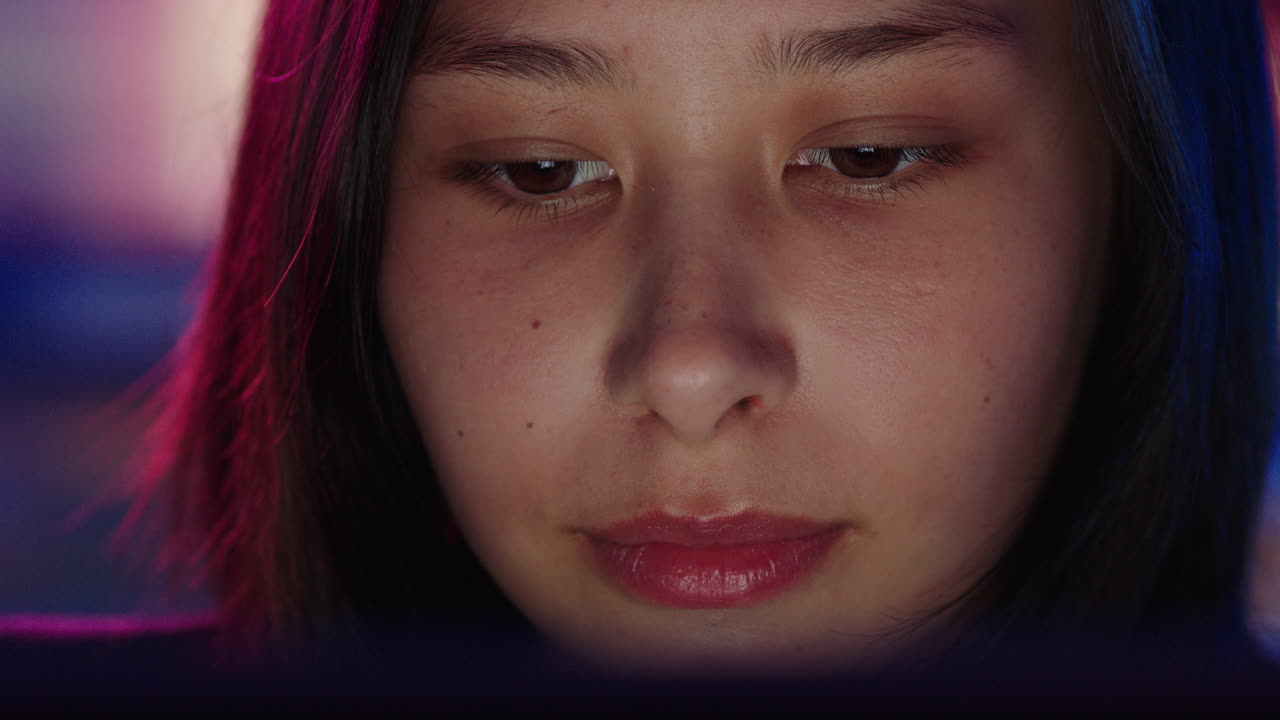 태블릿 컴퓨터를 사용하는 젊은 아시아 여성의 자세한 초상화 늦게 일하고 온라인 브라우징 스크린을 보고 인터넷 연결을 즐기고 있습니다.