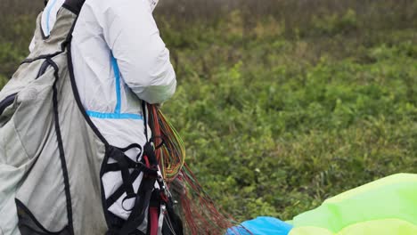 persona que prepara el equipo de parapente en un parque