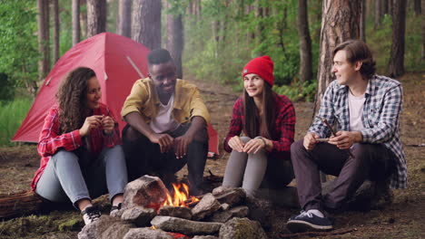 friends camping by campfire