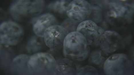 macro spinning blueberries under water with black background