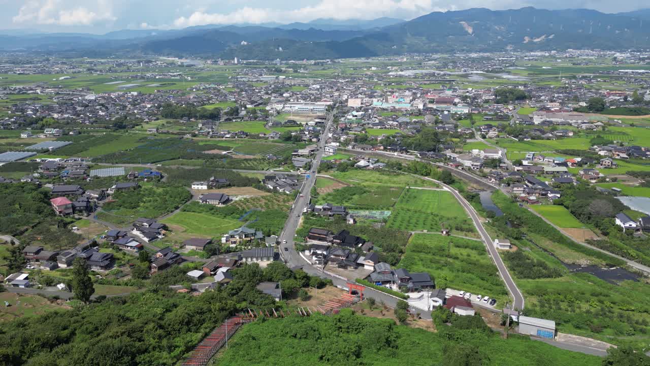 Drone tilt up over typical rural Japanese scenery with rice fields and houses