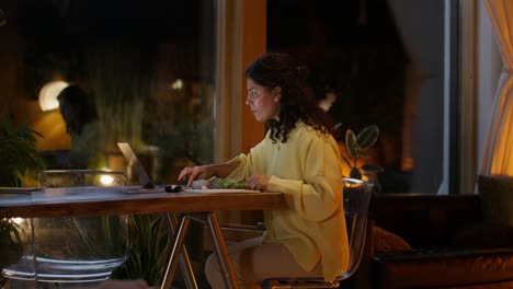 mujer trabajando y cenando en casa por la noche