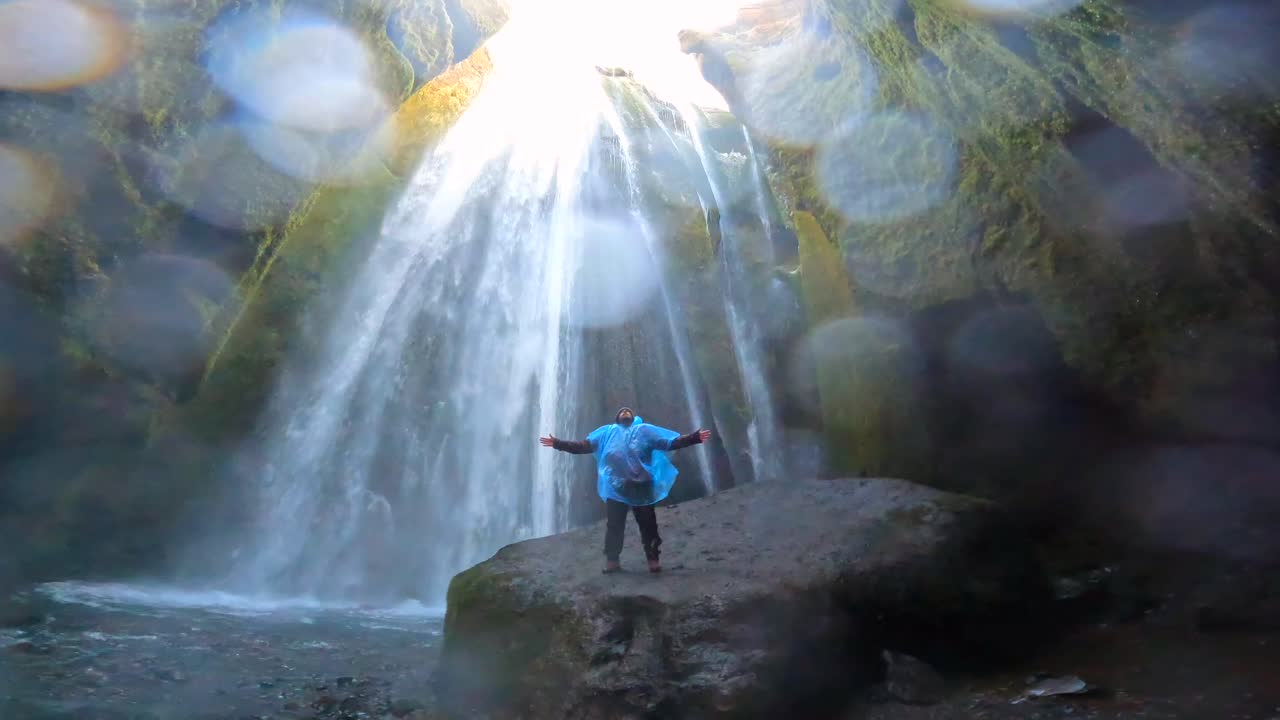 Mann an einem Wasserfall in einer Höhle