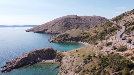 bahía de oprna en la isla de krk, croacia - vista aérea de drones de bahías con playas escondidas, agua azul clara y camino a lo largo de las montañas