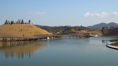 Visitantes-Paseando-Por-La-Colina-Bonghwa-Y-El-Puente-De-Los-Sueños-En-El-Jardín-Del-Lago-Suncheonman-Bay,-Ciudad-De-Suncheon,-Corea-Del-Sur