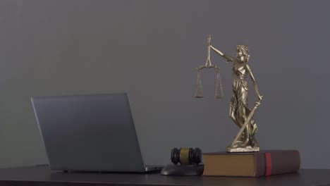 laptop judge hammer books and scales the goddess of justice on the lawyer's legal advisory concept table.