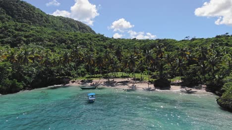 Scenic-Beach-Surrounded-By-Cliffs-And-Lush-Vegetation,-Playa-Madama-In-Las-Galeras,-Dominican-Republic---aerial-pullback