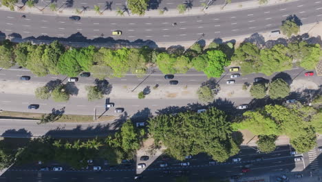 Top-down-aerial-footage,-ascending-into-the-air,-revealing-more-traffic-of-the-Botafogo-Bay-roads