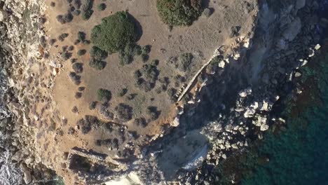 disparo bajo de un dron volando cerca de las ruinas de la isla deshabitada de yeronisos, la sagrada isla sagrada frente a la costa de chipre.