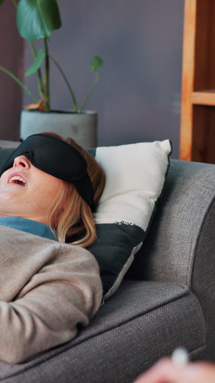 Woman sleeping on a couch with a blindfold