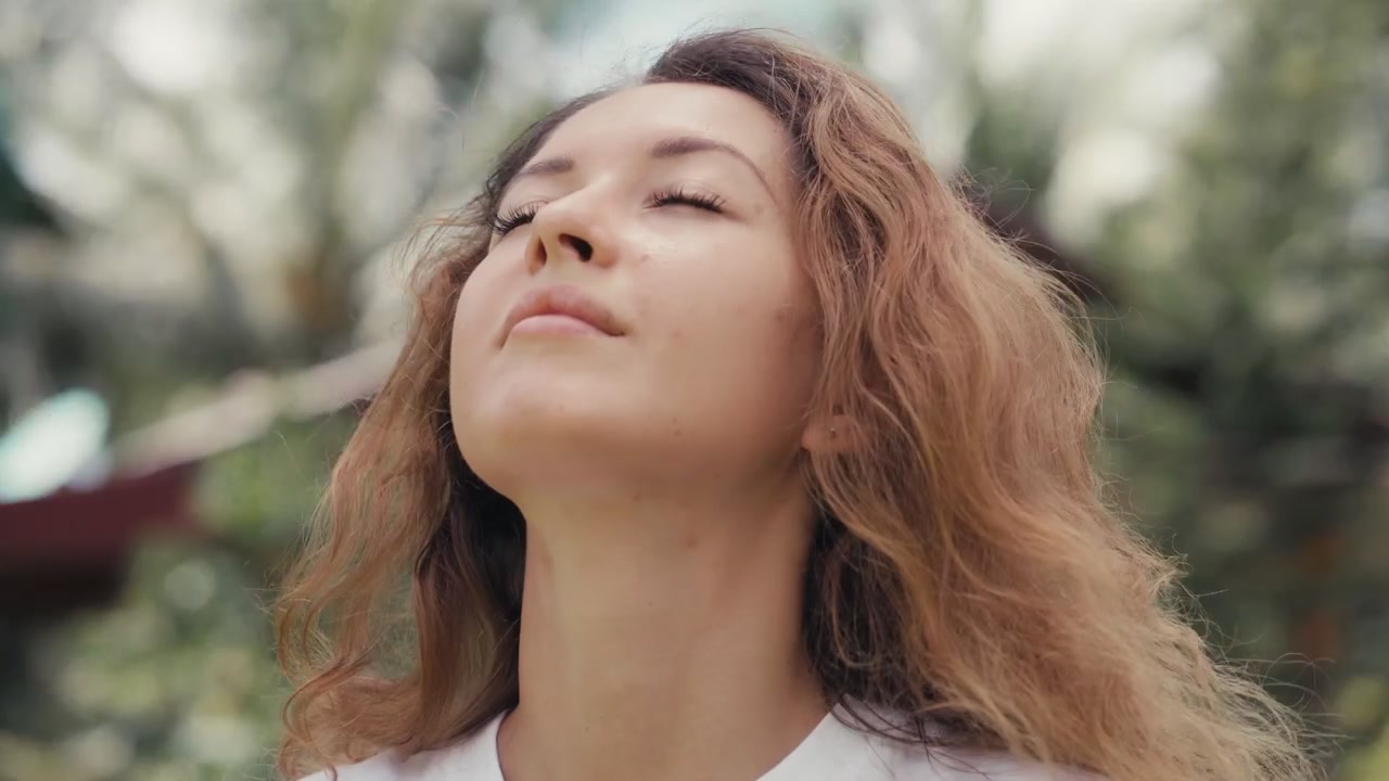 Giovane donna che si toglie la mascherina e respira aria fresca all'aperto
