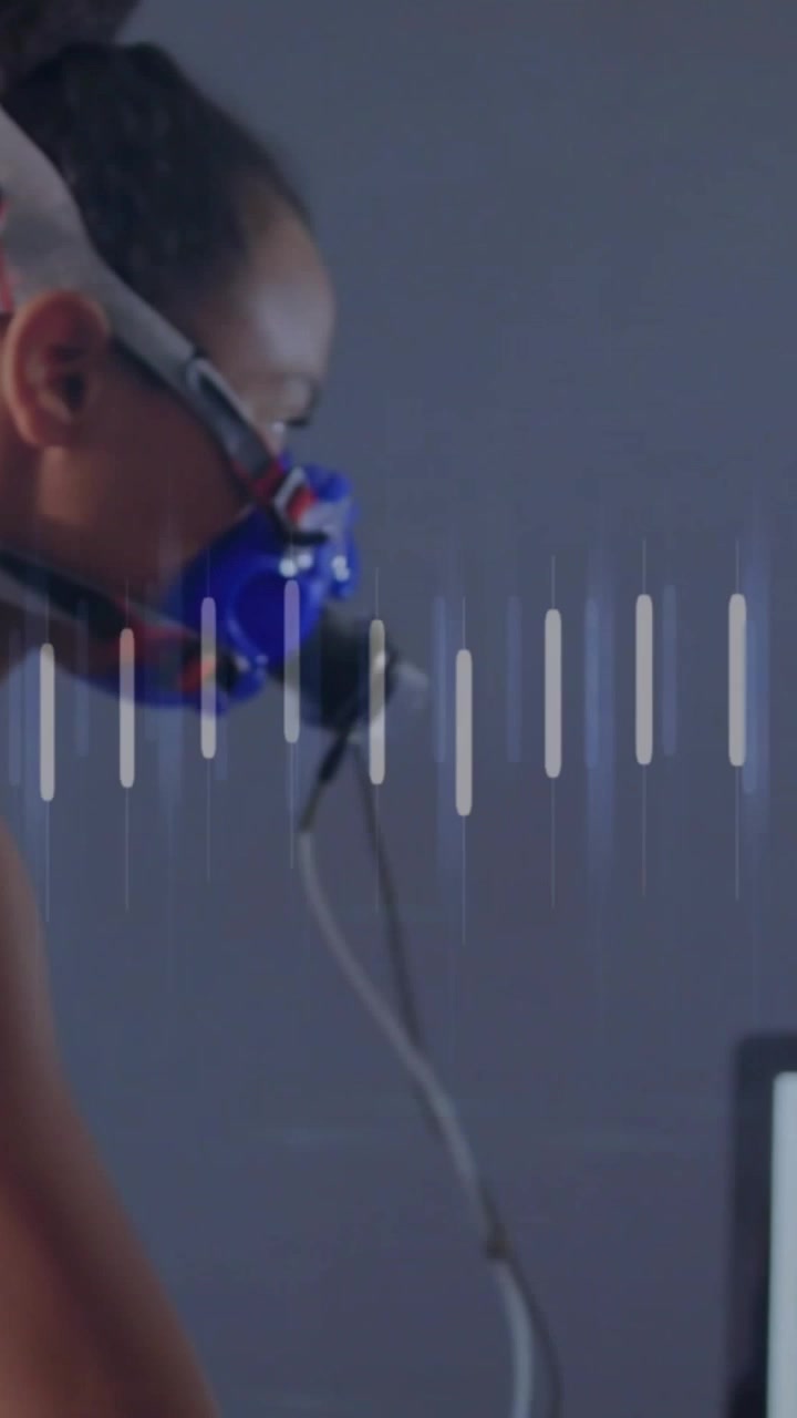 Vertical video: Woman breathing through blue mask driving animated orange line, bars for lab test