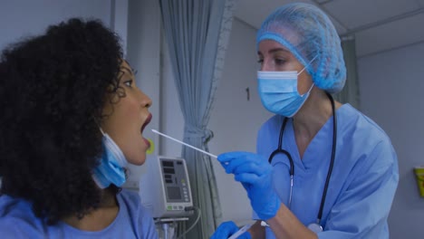 una doctora caucásica con máscara facial dando una prueba de esponja de covid a una paciente