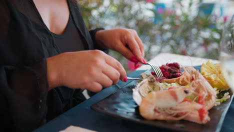 hands of a woman eating gourmet dish at the beach resort