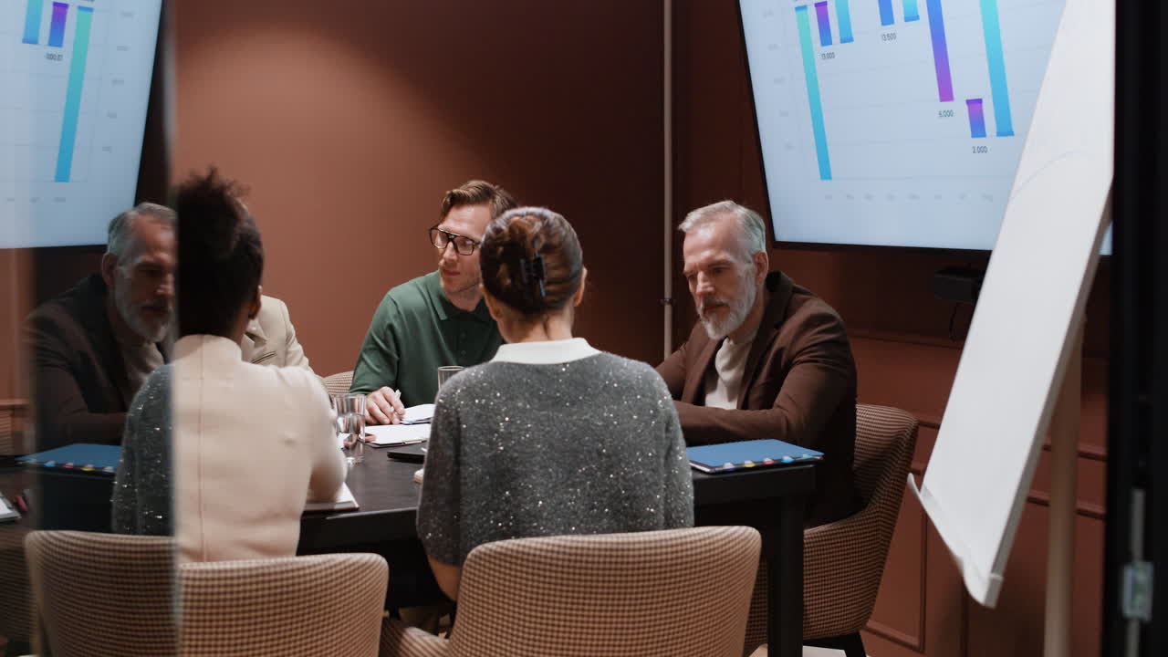 Professionals engaging in a business meeting with charts on display