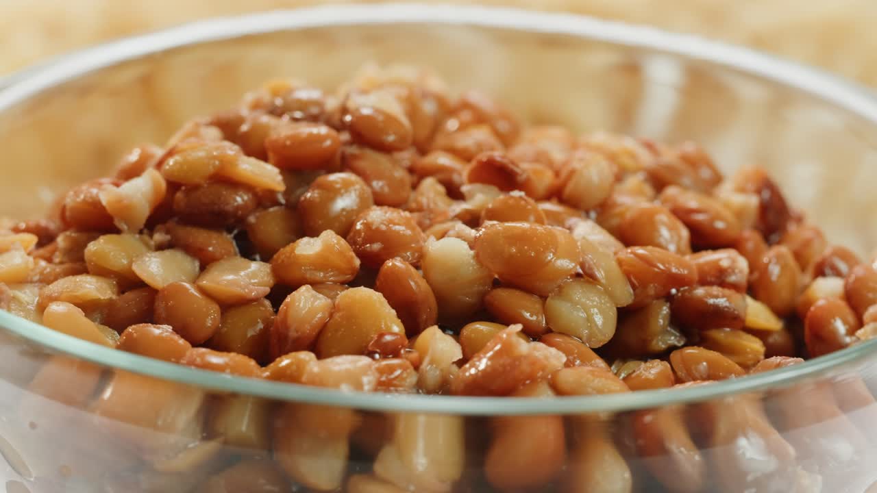 Lentils macro, Open metal can with preserved steamed brown lentils close up isolated on white background