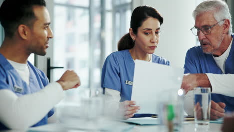 a group of doctors and nurses discuss a patient's medical record.