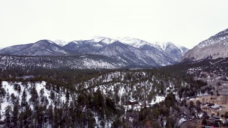 Snow-covered-Collegiate-Peaks-in-Colorado-on-an-overcast-day-during-the-winter,-drone-flying-forward