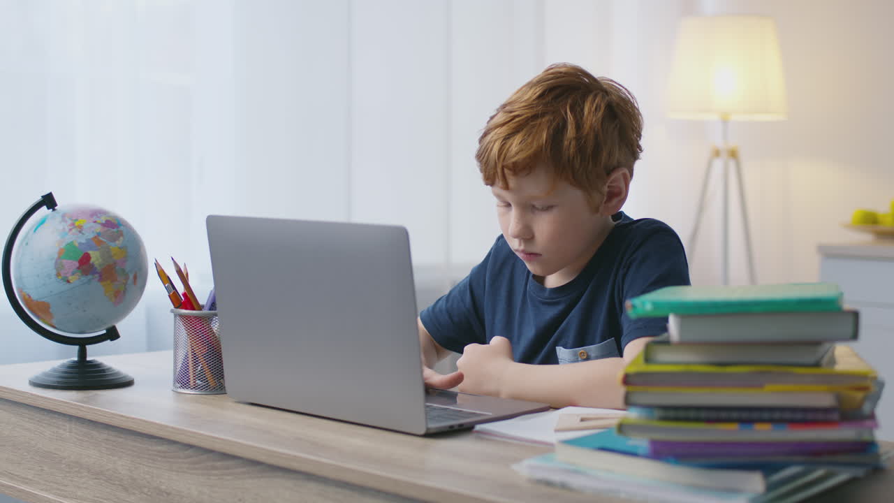 niño haciendo la tarea en la computadora portátil