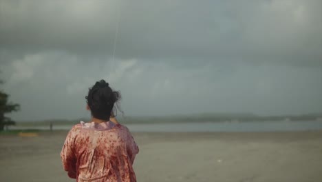 Beautiful-woman-dancing-on-beach-in-stormy-weather-in-slow-motion