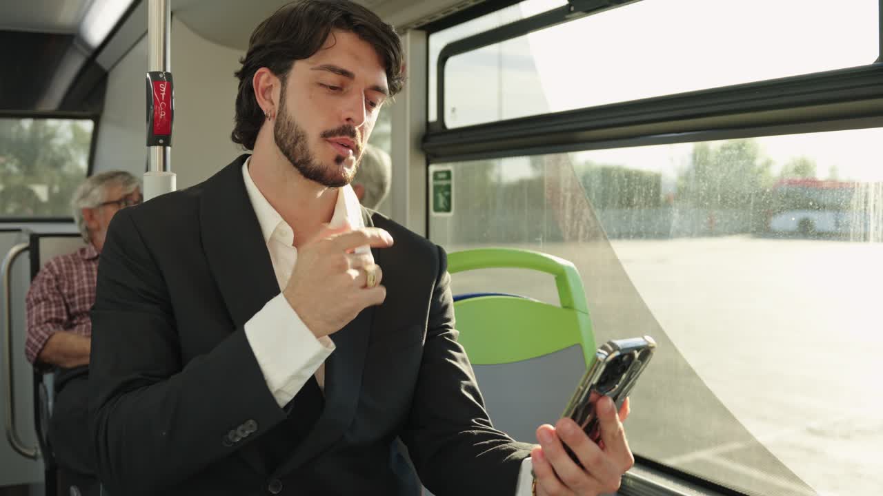 Man in suit using phone on a bus