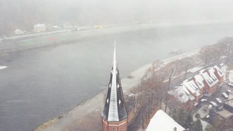 Drone-aerial-view-of-strong-snow-storm-in-Kaunas-old-town,-Lithuania