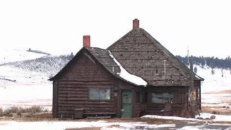 A-Large-Addition-Tacked-On-To-A-Small-Log-Cabin-Mirrors-Its-Steep-Roof-And-Chimney