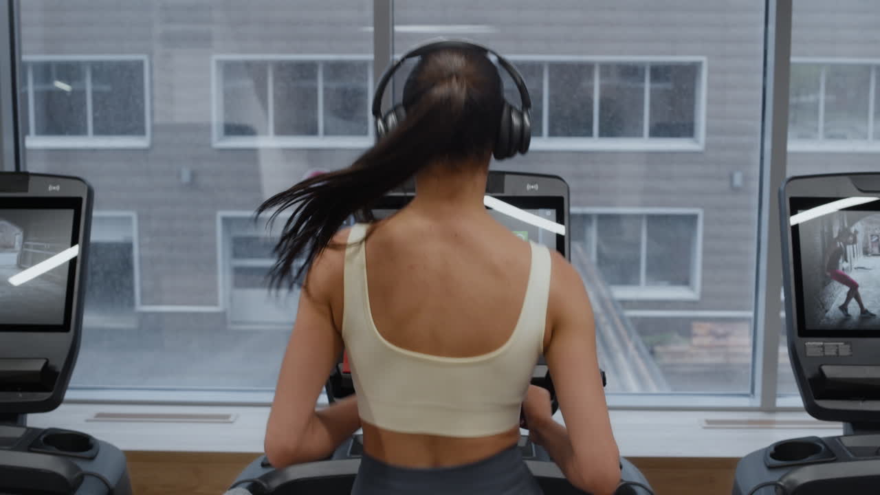 Woman exercising and running on a treadmill in a gym