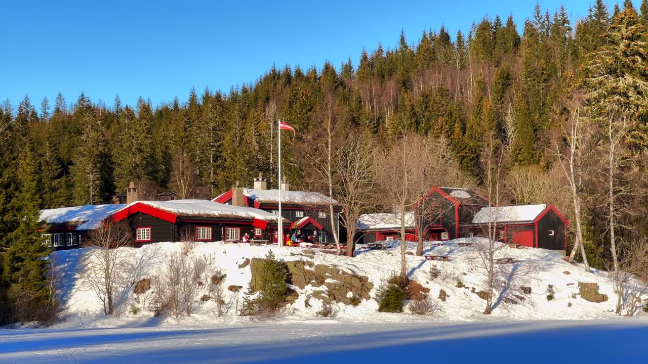 Holmenkollen Toppsesteret Skimore Oslo cross country skiing picturesque Red cabins Norway Norge flag Ski Frognerseteren Frognerseteren afternoon arctic golden hour sunset rest stop pan left motion