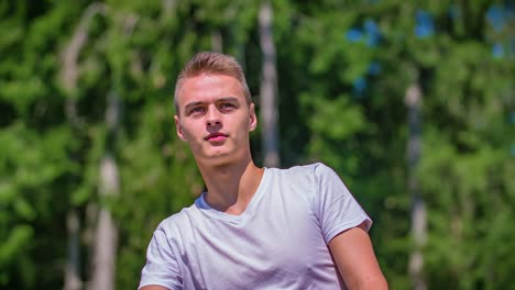 young adult male outside in sunny day pointing into the distance