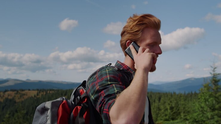 Man catching network signal in smartphone on the mountains