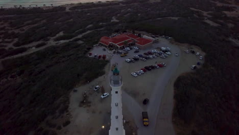 Toma-Aérea-Del-Faro-De-California-Justo-Después-Del-Atardecer-En-Aruba-Con-El-Mar-Caribe-De-Fondo