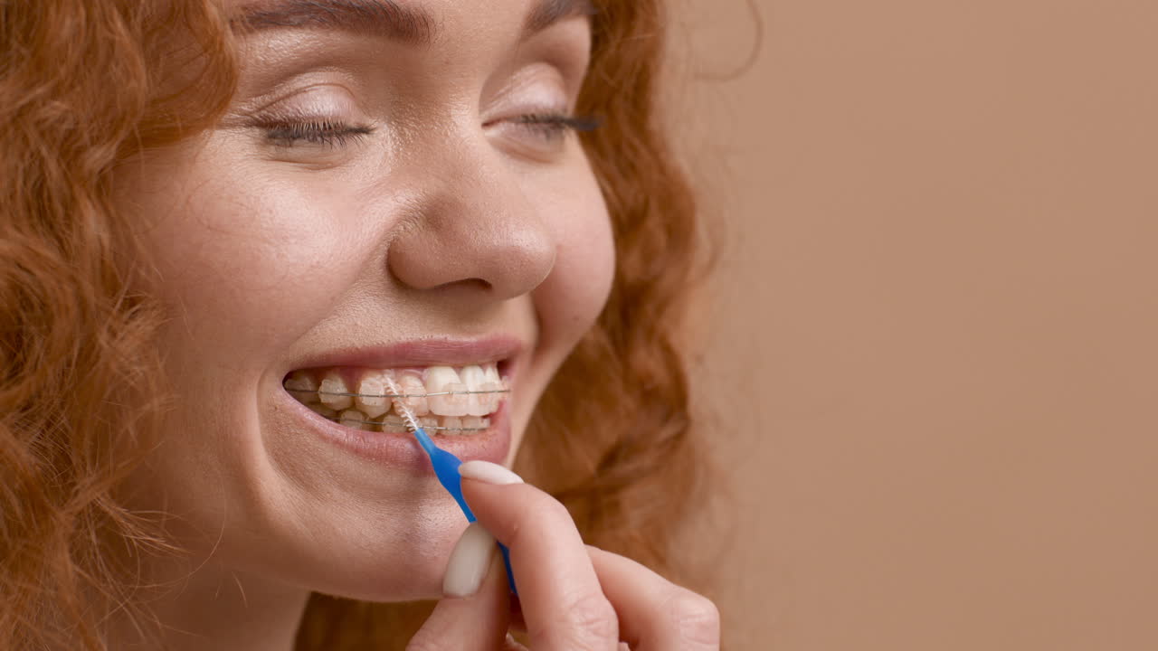 Woman Cleaning Her Braces with an Interdental Brush