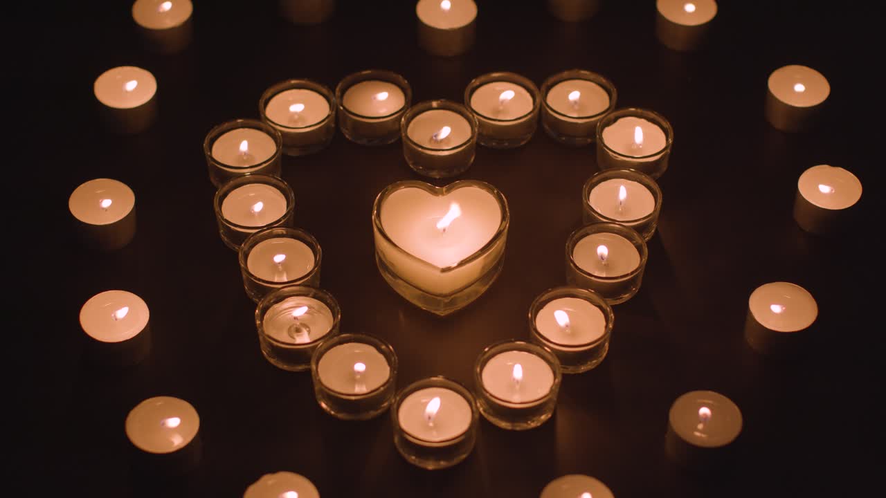 velas blancas románticas en forma de corazón sobre fondo negro