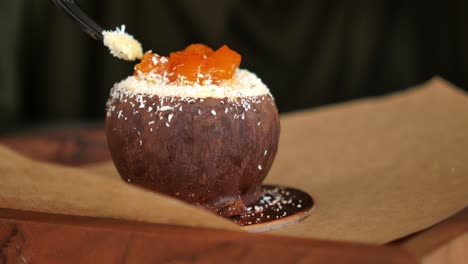 person eating a chocolate coconut dessert