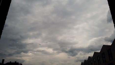 dramatic timelapse shot from an apartment window, sky darkening just before rain