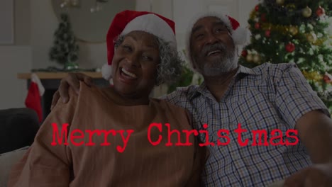 Animation-Eines-Frohe-Weihnachts-Textes-über-Einem-älteren-Afroamerikanischen-Paar-Mit-Weihnachtsmützen