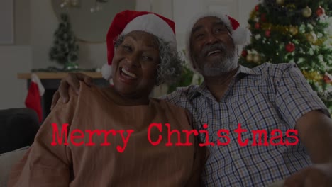 Animation-of-merry-christmas-text-over-senior-african-american-couple-wearing-santa-hats