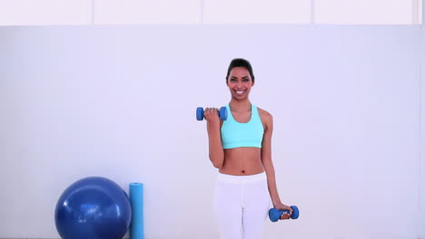 mujer en forma de pie y levantando pesas con las manos