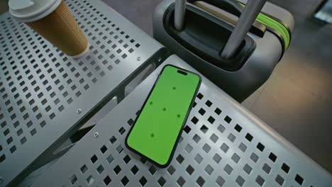 smartphone with green screen on airport seat