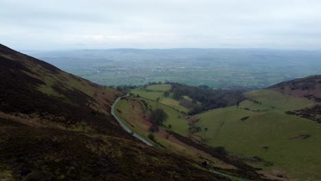 narrow single rural road running through welsh green mountain valleys landscape aerial dolly right