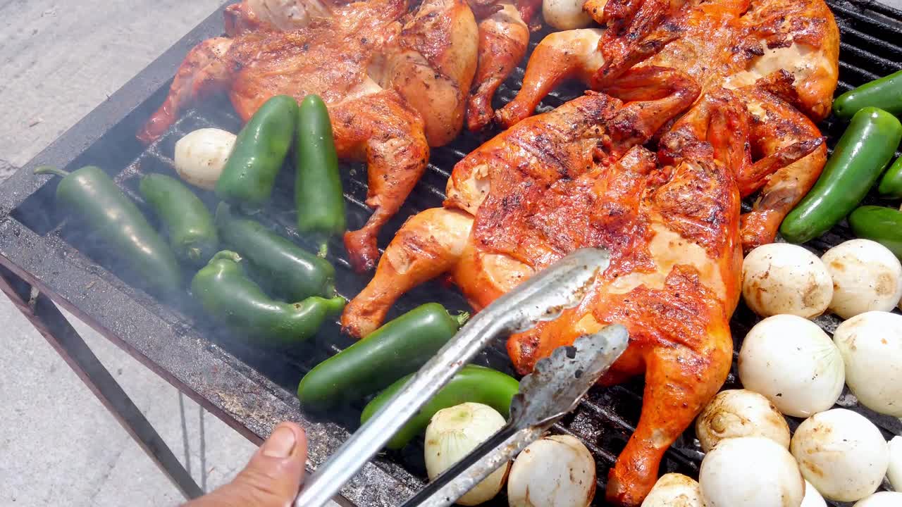 chef flipping grilled chicken on a barbecue with jalapeños and onions. Traditional Mexican street food scene with smoke, fire, and vibrant outdoor cooking atmosphere