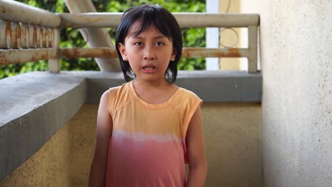 portrait of a young southeast asian outdoors on a sunny day with an itchy nose and cutely sneezing into camera