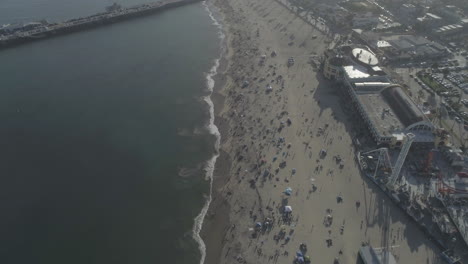 aerial - people on the beach next to beach boardwalk