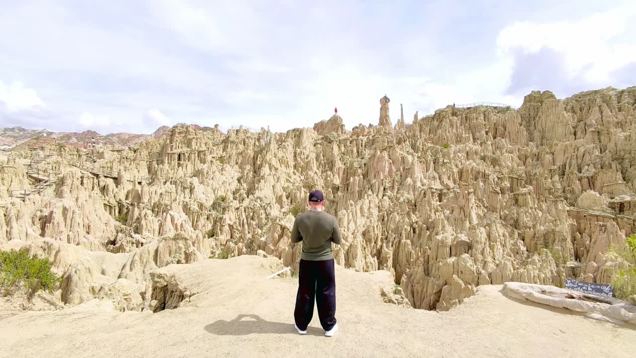 Filmagem de drone selfie de homem contemplando o Valle de la Luna em La Paz, Bolívia