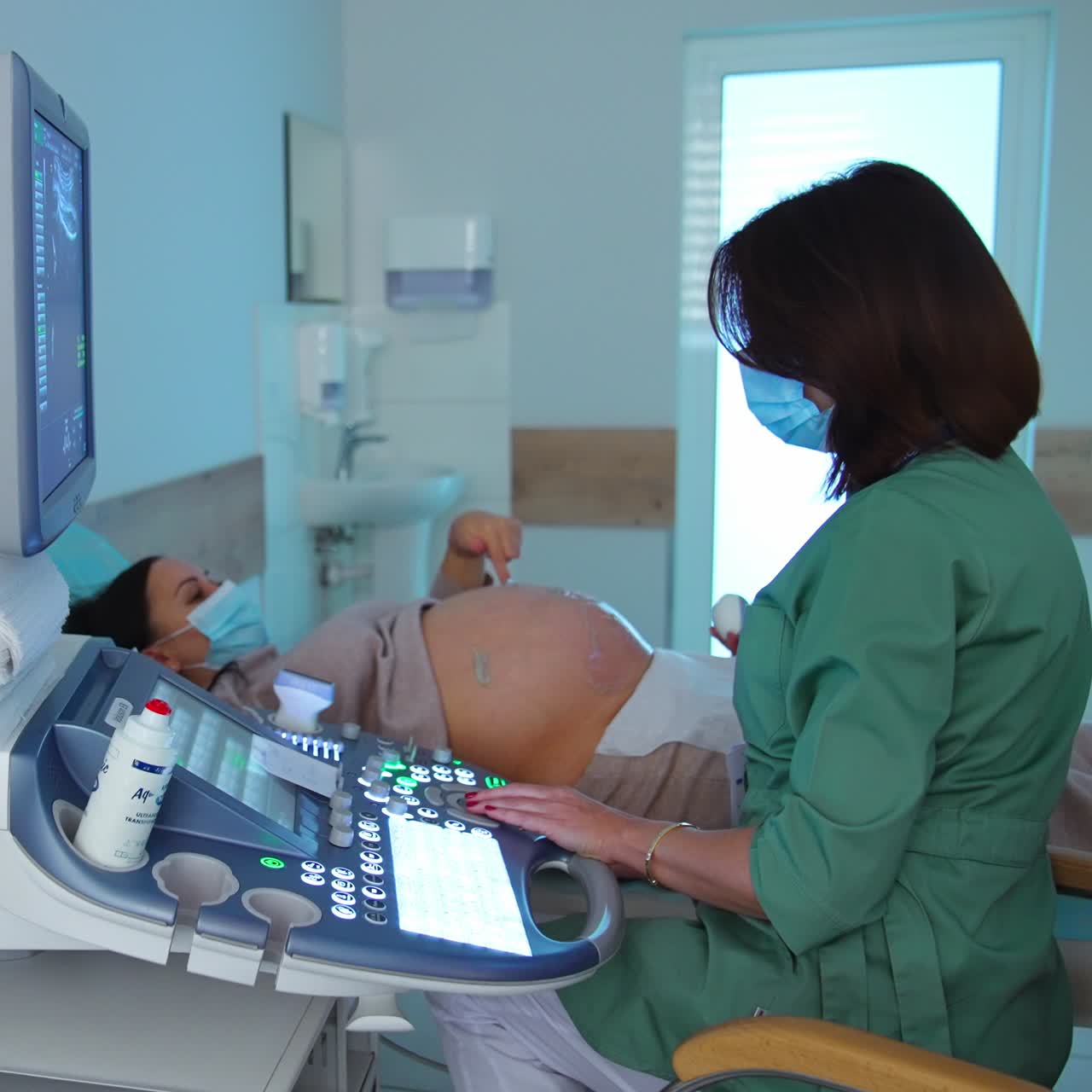 Modern advanced ultrasonic apparatus for diagnostics. Obstetrician performing ultrasound scanning for future mom