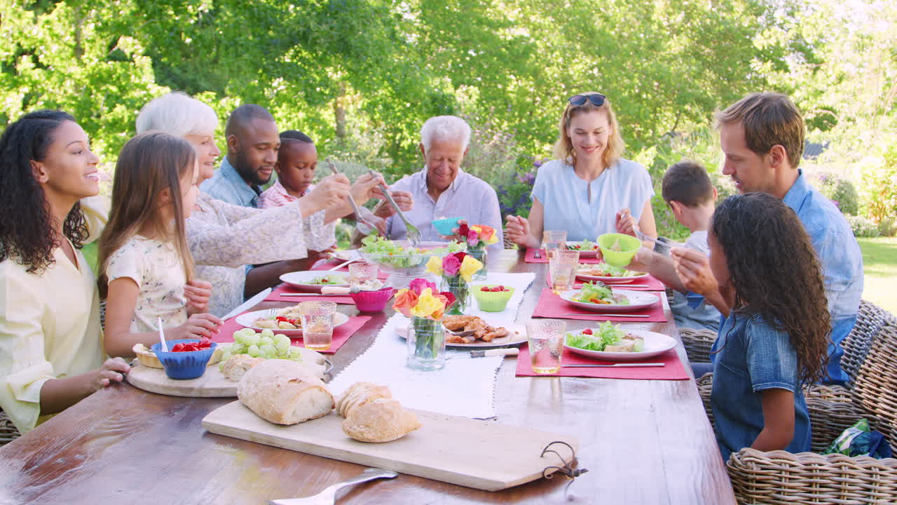 Friends and family having lunch at a table in the garden